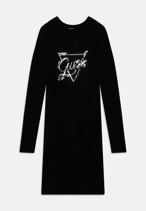 Sort langærmet knælængde kjole med rund hals og skinnende sølv "Guess" logo inde i en afgrænset trekant på brystet.