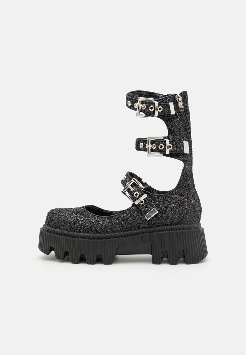 Chaussure à plateforme noire pailletée avec trois brides réglables à la cheville, boucles argentées, fermeture éclair au talon et semelle épaisse et robuste avec des crampons profonds.