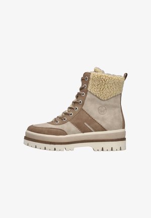 Tan- und beige Schnür-Ankle-Boots aus Wildleder, mit einem weißen, fellgefütterten Kragen, verziert mit metallischen Ösen und einer dicken Gummisohle.