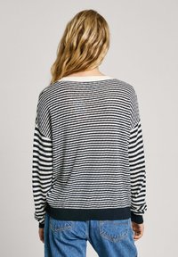 Randig tröja i marinblått och krämfärgat, löst sittande passform, ribbade ärmslut och fåll, stickad textur, med sidoseams och sänkta axlar.