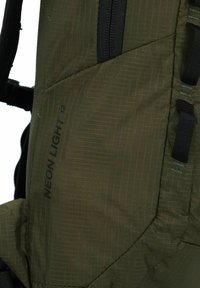 Grüner Stoffrucksack mit Karomuster, schwarzen Reißverschlüssen und mehreren Riemen; seitlich mit "NEON LIGHT 12" beschriftet.