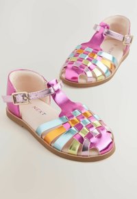 Vævede metal-sandaler med pink, blå og gyldne nuancer, en ankelsnicre og åben tå-design. Glat tekstur og flad sål.