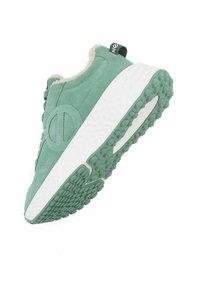 Baskets en suede vert avec doublure en peluche, semelle intermédiaire blanche, semelle en caoutchouc texturé avec des grips ronds, et un détail de logo circulaire sur le côté.