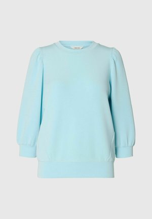 Svetlo modra pulover majica z okroglim izrezom in napihnjenimi rokavi. Gladka tkanina z mehkobo in sproščenim krojem. Vključeni so stranski žepi.