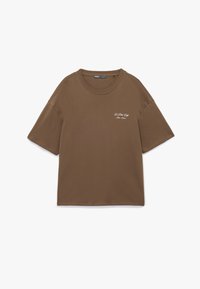 Brun bomulds t-shirt med korte ærmer, rund halsudskæring og broderet tekst i hvid, som læser "Le Petit Café, Paris Frankrig."