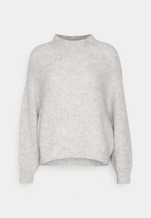 Šviesiai pilkas megztinis su aukštu kaklu, nuleistais pečiais ir raštuotu paviršiumi. Turi šiek tiek trumpą apačią ir ilgomis rankovėmis.