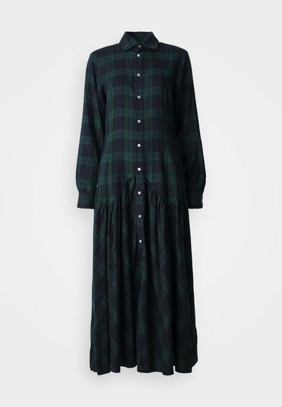 Long plaid dress in dark green and black, featuring a button-up front, a collar, and gathered detailing at the waist for a flowing silhouette.