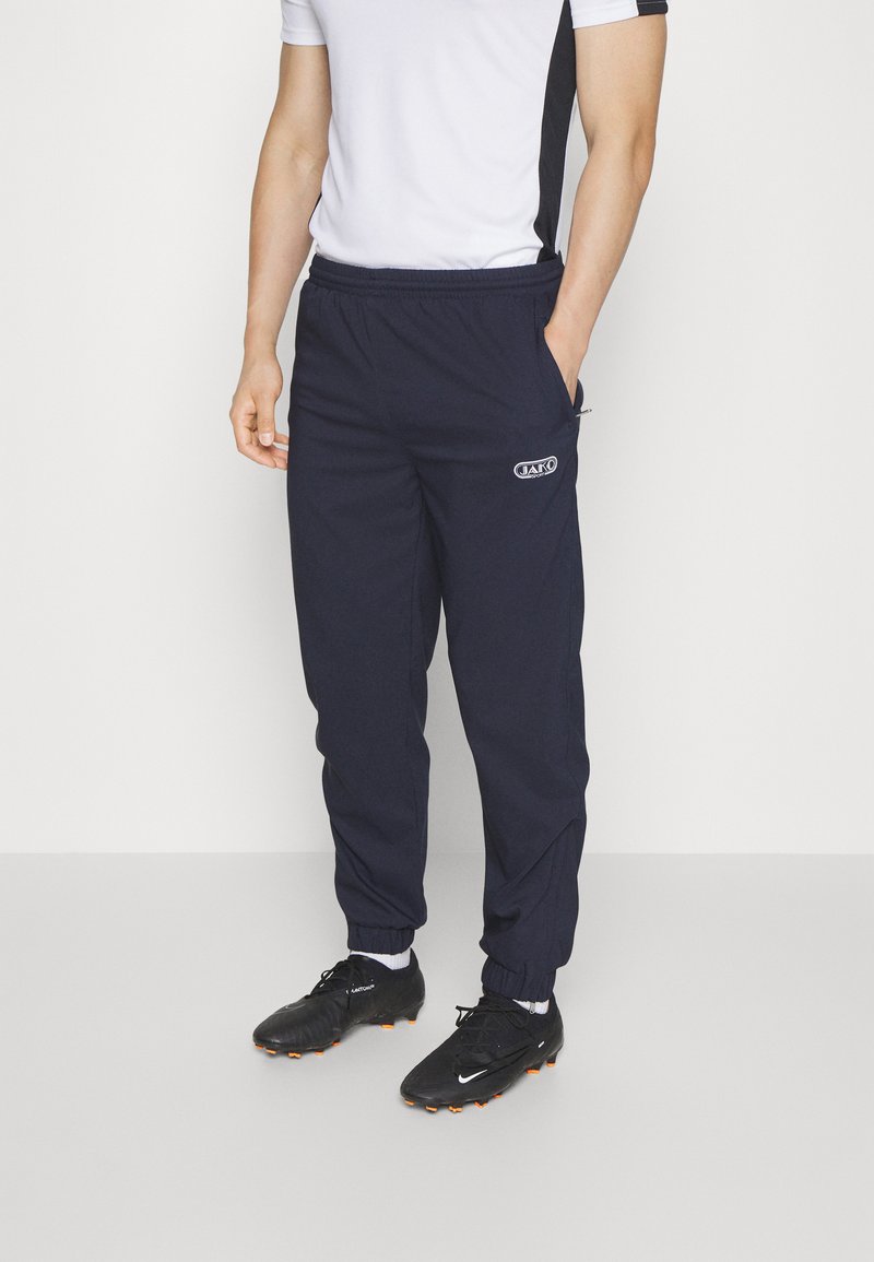 Navy-Trainingshose mit elastischem Bund und Bündchen, seitlichen Taschen und einem kleinen Logo an der Hüfte, aus einem leichten Stoff gefertigt.