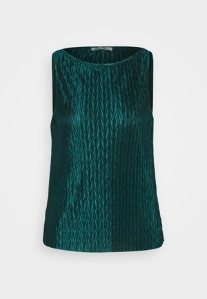Teal sleeveless top made of textured fabric featuring a chevron pattern; round neck and smooth, shiny finish. Exposed stitching at hem.