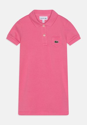 Pink kortærmet polo-kjole med krave, to knapper, en lille brystlomme og en grøn krokodillelogo på lommen.