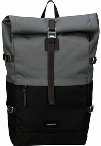 Grauer und schwarzer Rucksack mit Rollverschluss aus strapazierfähigem Stoff, mit metallischen Schnallen, verstellbaren Trägern und einem oberen Tragegriff.