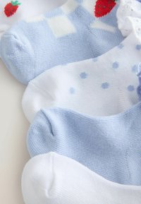 Quatre paires de chaussettes pour bébé en bleu et blanc avec des motifs variés, comprenant des rayures, des pois, des fraises et un bord en dentelle.