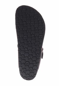 Zwarte rubberen sandaalzool met een gestructureerd oppervlak met cirkelvormige en ovale patronen voor grip en tractie. Rond en plat ontwerp.