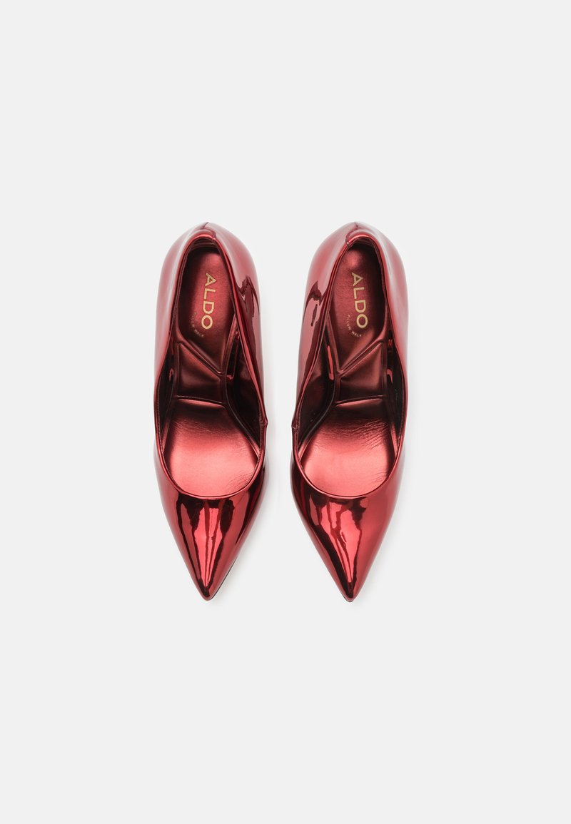 Escarpins rouges en cuir verni à bout pointu avec une finition brillante. L'intérieur présente des semelles rembourrées et un design simple sans quincaillerie visible.