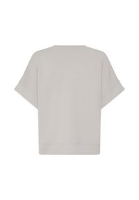 Haut à manches courtes gris clair avec une coupe large et carrée et des manches retroussées, vu de dos sur un fond blanc.