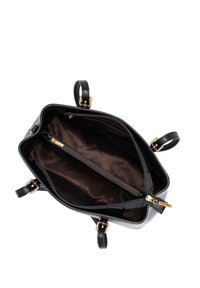 Sac à main en cuir noir avec quincaillerie dorée, fermeture éclair, et doubles compartiments à l'intérieur, présentant une texture lisse et une doublure marron foncé.