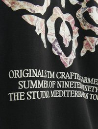 Tricou din material negru, cu un grafic mare texturat în tonuri deschise, având modele abstracte și text alb în partea de jos.