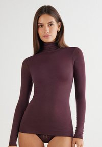 Burgundowy longsleeve z golfem wykonany z miękkiego, elastycznego materiału; dopasowany krój z gładką teksturą i minimalistycznym wzornictwem.