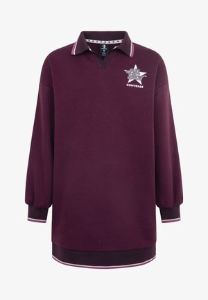 Polo majica dugih rukava u tamnocrvenoj boji s V-izrezom, kontrastnim ovratnikom, gumiranim logotipom i prugastim manžetama. Izrađena je od meke pamučne mješavine.