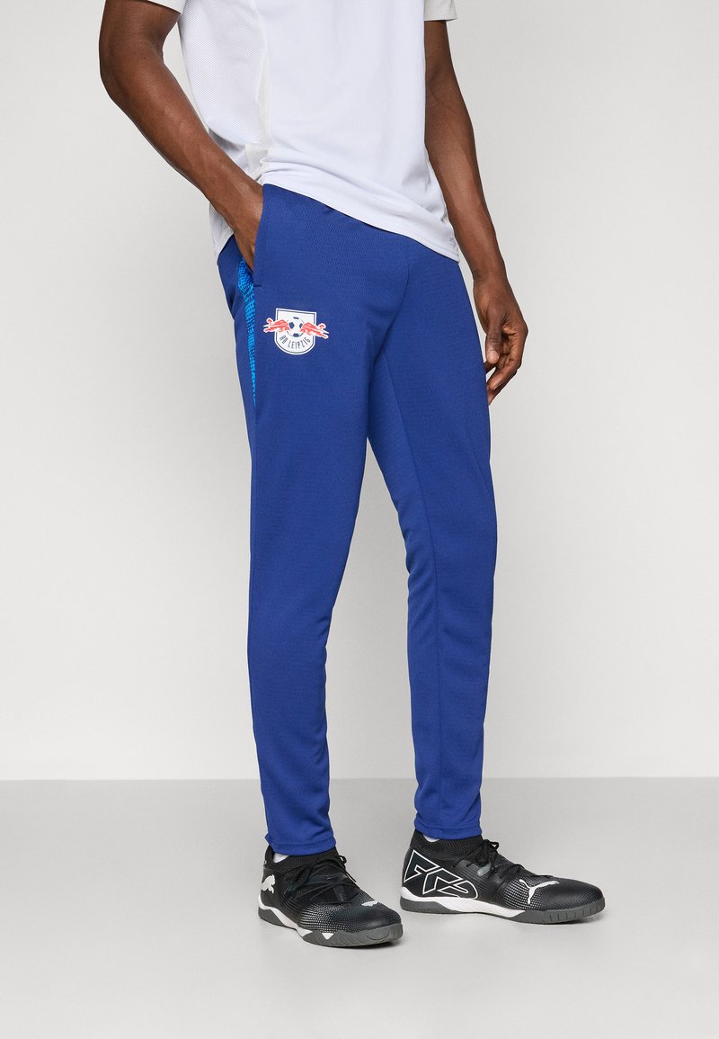 Pantaloni de trening albaștri dintr-un material moale, cu un logo pe lateral și accente contrastante de culoare albastră, proiectați cu două buzunare laterale.