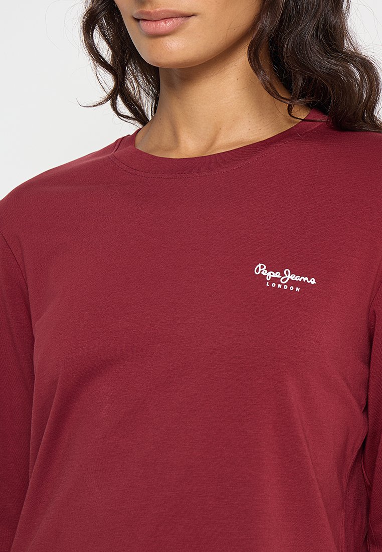 Bordeauxrood langwerpig T-shirt van katoen met een ronde halslijn. Voorzien van een witte "Pepe Jeans London" logo op de borst. Soepele textuur.