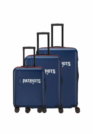 Drei dunkelblaue Hartschalen-Koffer mit ausgezogenen schwarzen Griffen, jeder zeigt das Wort "Patriots" und ein Team-Logo in Weiß.