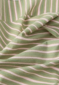 Ύφασμα με πράσινες και κρεμ ρίγες, με απαλή υφή, που διαθέτει κυματιστές γραμμές και λείες επιφάνειες, κατάλληλο για διάφορες υφαντουργικές εφαρμογές.