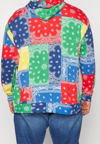 Wielokolorowa bluza z kapturem wykonana z bawełny, z wzorem patchworkowym w niebieskie, czerwone, zielone i żółte sekcje, ozdobiona wzorami paisley.