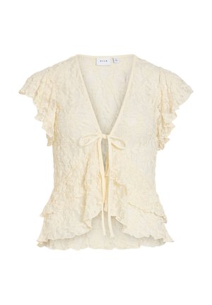 Kremowa koronkowa bluzka z krótkimi falbaniastymi rękawami, głębokim dekoltem w kształcie litery V, wiązaniem z przodu oraz warstwowymi falbanami wzdłuż dołu i przedniego rozcięcia.