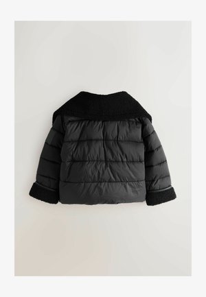 Juodas pūkinis švarkas su tekstūruotu, pūkuotu apykakle ir rankogaliais. Yra dvigubo audinio modelis ir elastingi rankogaliai, užtikrinantys gerą prigludimą.