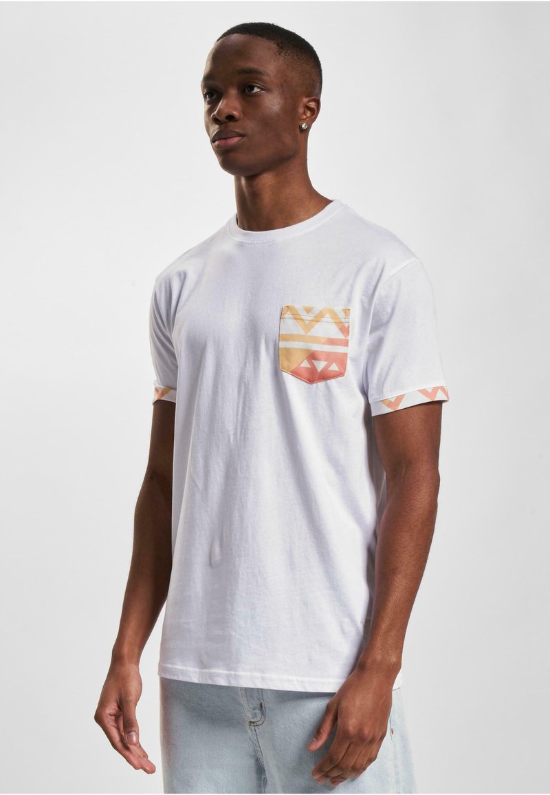 White cotton T-shirt with a patterned pocket in orange and yellow, featuring geometric designs. Short sleeves with matching accents.
