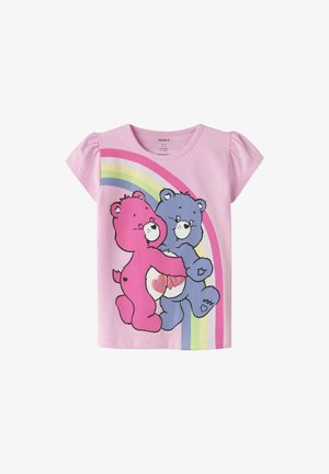 T-shirt enfant à manches courtes rose avec deux ours en dessin animé qui se font un câlin en rose et violet, un arc-en-ciel pastel en arrière-plan.