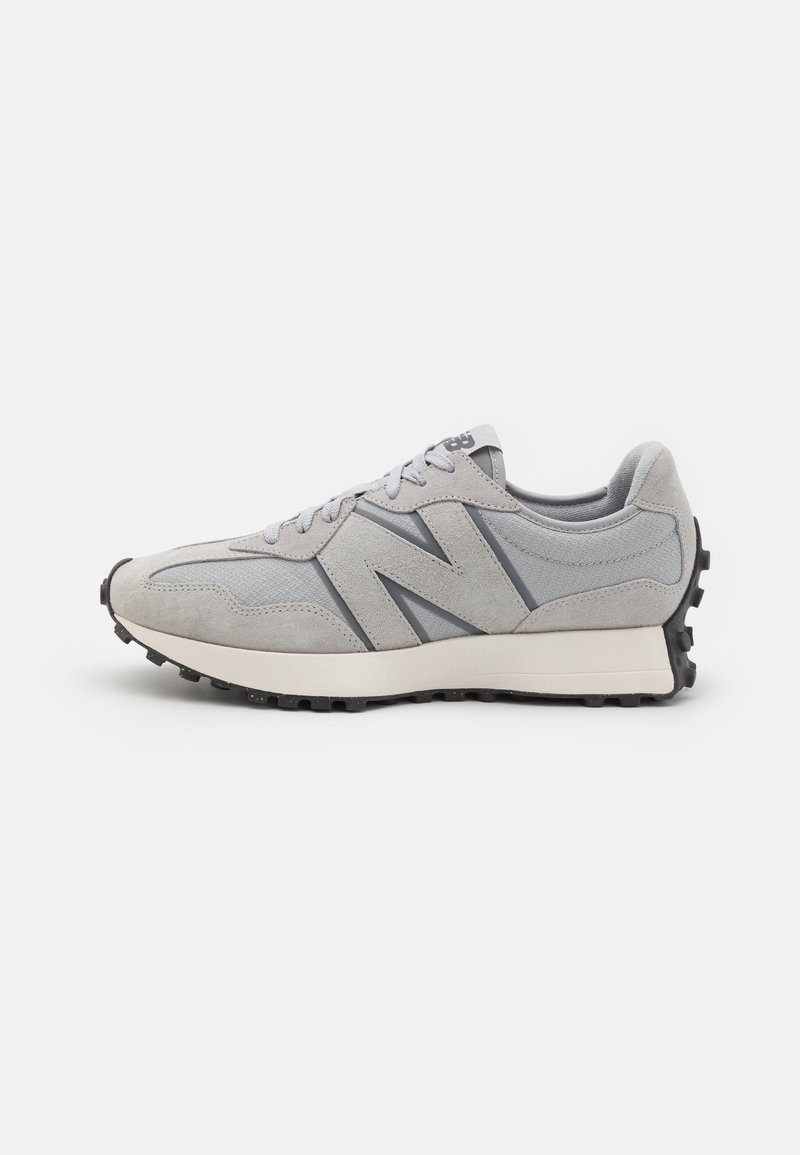 Baskets New Balance gris et beige clair avec dessus en suède et mesh, fermeture à lacets, et semelle extérieure en caoutchouc noir texturé.