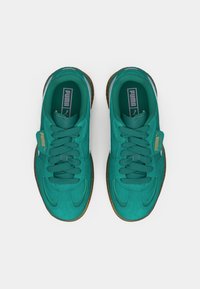 Roheline sametist tossud sileda pinnaga, ümara paelaga, pruuni kummist tallaga ning PUMA brändinguga keelel ja küljel.