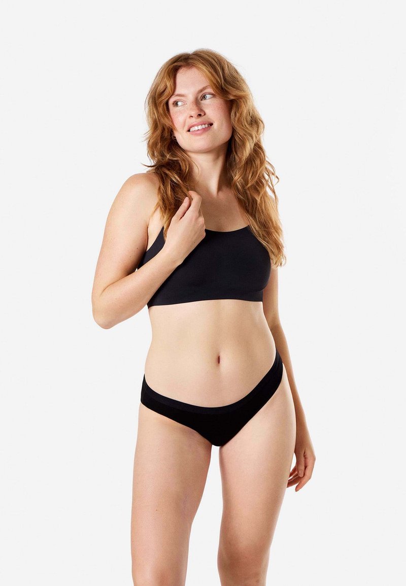 Set di bralette e slip neri realizzati in tessuto morbido. La bralette presenta un design con fascia, mentre lo slip ha un taglio a vita bassa con un semplice elastico in vita.