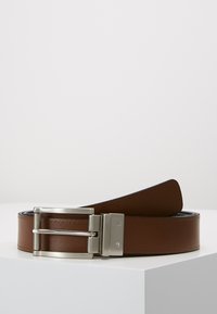Cintura in pelle marrone con una texture liscia, dotata di una fibbia in metallo argentato, design piatto e uno stile pulito e minimalista.