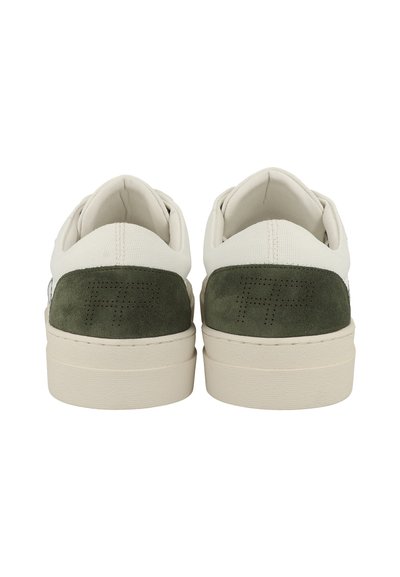 Weiße und grüne Sneaker mit einem Wildleder-Fersenbereich, strukturiertem Stoff und einer flachen, cremefarbenen Sohle. Verfügt über dezente Perforierungen im hinteren Bereich.