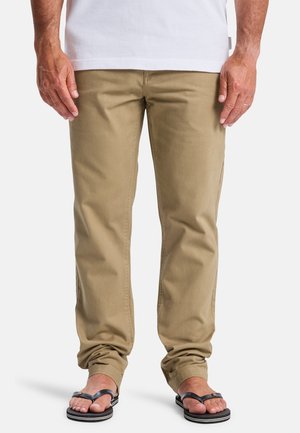Khaki cotton pants with a straight fit, featuring front pockets and subtle stitching details, paired with black flip-flops.