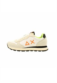 Baskets blanches et beiges avec logo orange, en matériaux en daim et en mesh, accents noirs sur le talon, doublure intérieure verte et semelle en caoutchouc.
