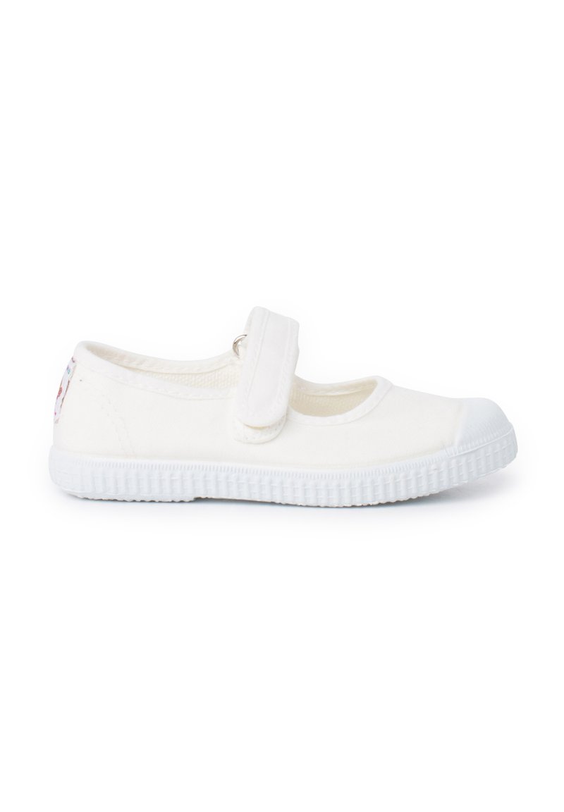 Zapatos Mary Jane de lona blanca con cierre de Velcro, diseño de punta redonda, suela de goma texturizada y un pequeño detalle decorativo en el talón.