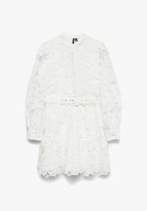 Abito bianco in pizzo con maniche lunghe a sbuffo, chiusura frontale con bottoni, vita con cinturino e motivi floreali; dettaglio dell'orlo arricciato.