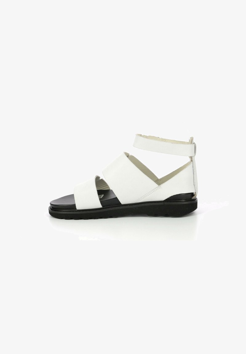 Sandale blanche avec larges brides croisées et bride cheville sécurisée, semelle noire, matériau en cuir lisse, design plat et détails minimalistes.