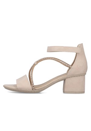 Beige sandal med åben tå og blokhæl, ankelrem samt dekorative krydsede perlebesatte stropper på siden.