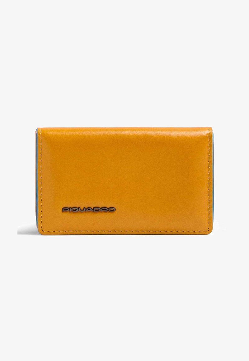 Portefeuille compact rectangulaire en cuir jaune moutarde avec coutures apparentes et logo Piquadro noir sur le devant.