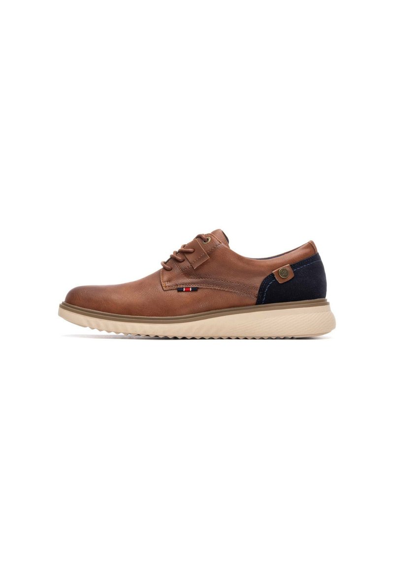 Zapatos de cuero marrón con cordones, acento en ante azul marino, suela de goma y detalles de costura visibles. Diseño ligero y casual.