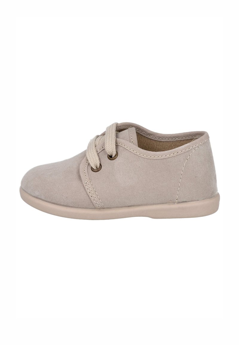 Zapatillas de lona beige con punta redonda, diseño de cordones, ojales dorados y suela de goma suave. Textura suave con detalles de costura mínimos.