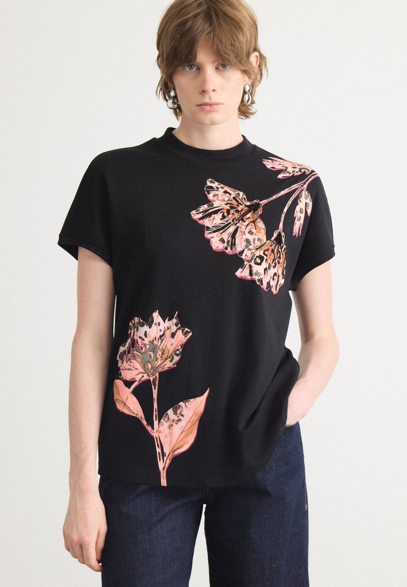 Camiseta negra de manga corta con estampados florales en colores rosa y naranja, de corte relajado y escote redondo.