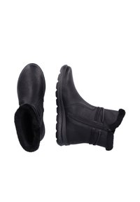 Bottines en cuir noir avec doublure en fausse fourrure, zip sur le côté et semelle en caoutchouc texturée, dotées d'un bout arrondi et d'un col rembourré.