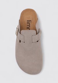 Gray suede slip-on shoe with a rounded toe, featuring a wide strap and side buckle accent. Interior has a tan footbed with logo.