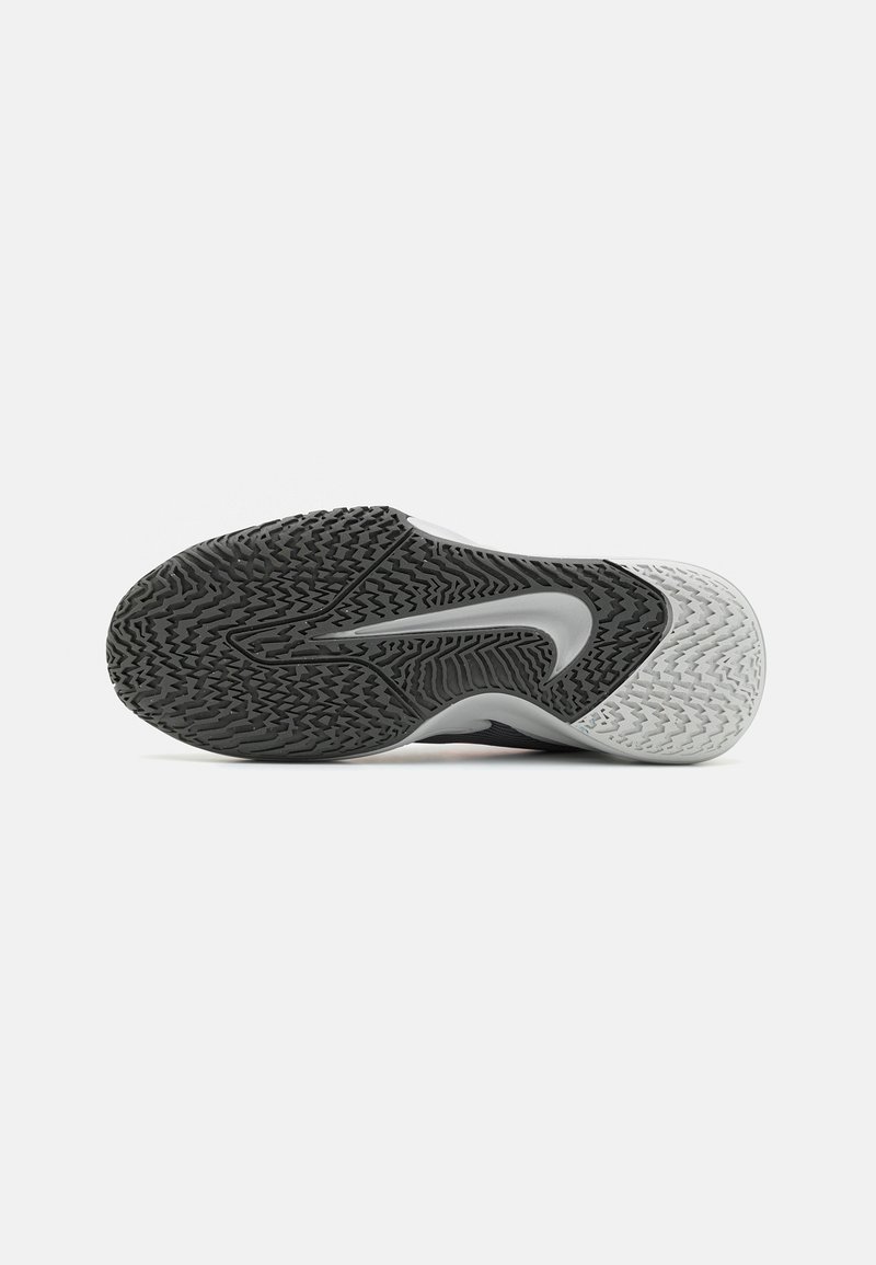 Semelle de chaussure de sport en noir et blanc affichant une surface texturée, un motif de semelle proéminent et un design moulé avec un profil incurvé.
